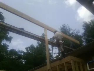 Carpenter setting a ridge beam over a new addition frame — Ice Dam Removal by Roofing Brothers in Clarion