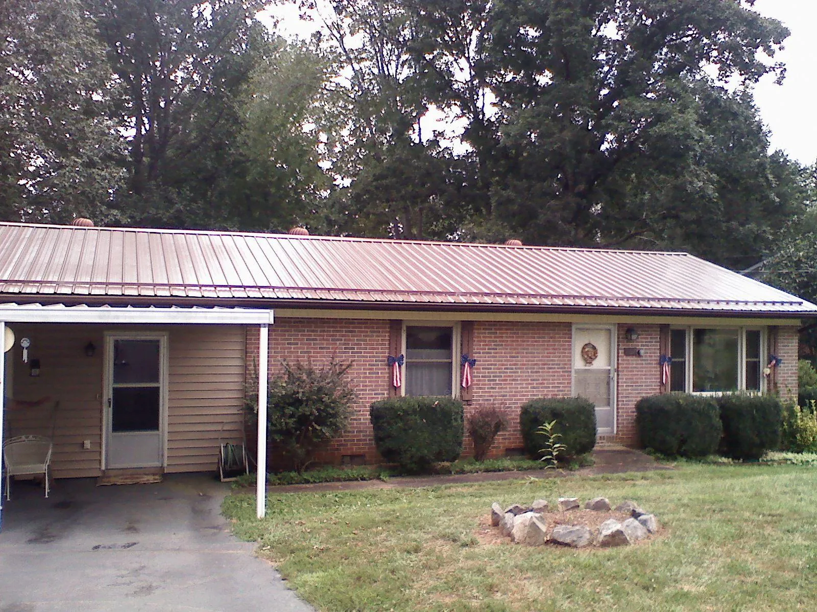 Bronze metal roof and carport on a brick ranch home — Roof Repair work by our crew in Clarion